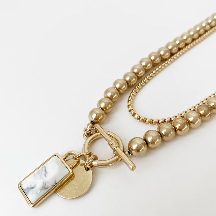 Collier perles métalliques avec breloque